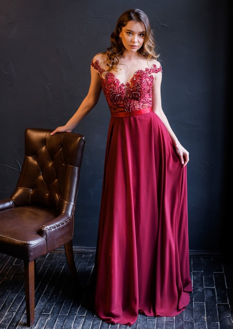 vista-frontal-chica-elegante-vestido-rojo-inclina-sobre-silla-mira-camara_8353-11655